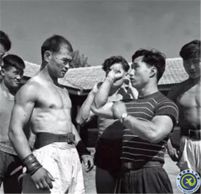 △1959年，在第一届全国运动会上，陈镜开（右二）为新疆运动员讲解技术动作.jpg